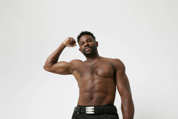 Αφροαμερικανός αθλητικός νεαρός με ασκήσεις μυών. Αποπλάνηση. Υψηλής ποιότητας φωτογραφία. - Φωτογραφία, εικόνα