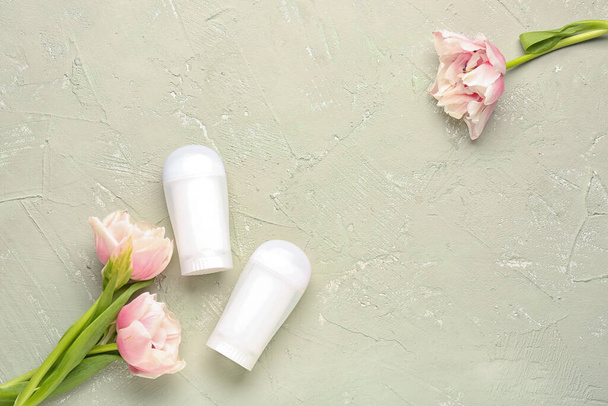 Deodorants and flowers on grunge background - Photo, image