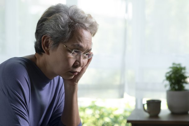 Portrét smutné a osamělé asijské starší ženy v obývacím pokoji - Fotografie, Obrázek