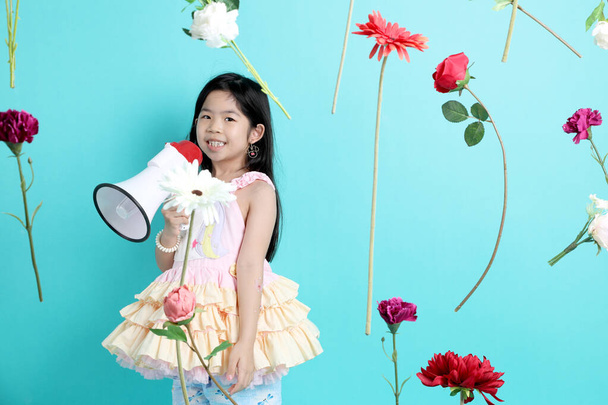 Malá asijská dívka s plovoucí květiny na zeleném pozadí. - Fotografie, Obrázek