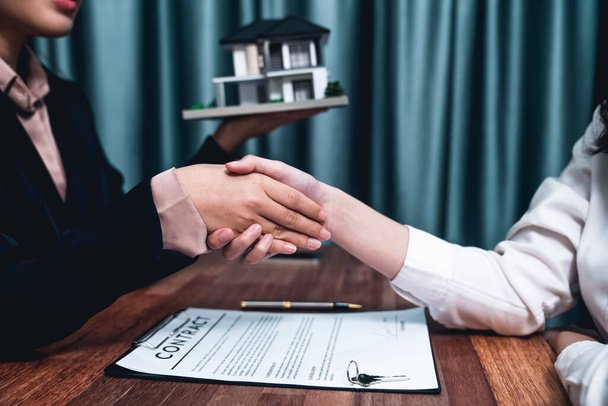 Successful house loan agreement sealed with a handshake. Buyers and agents celebrate the home ownership of property with a sense of accomplishment and satisfaction. Enthusiastic - Photo, Image