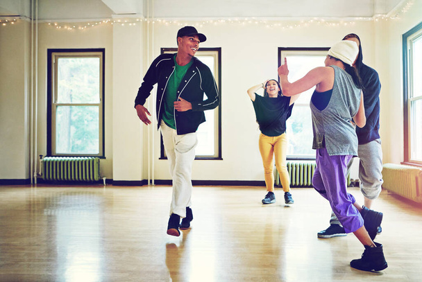 Le temps passé dans le studio de danse est bien passé. un groupe de jeunes amis dansant ensemble dans un studio - Photo, image