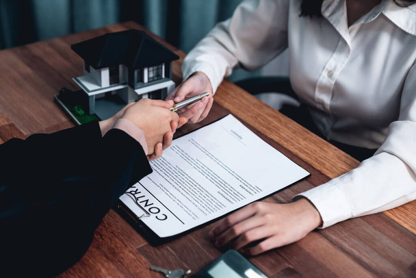 Завершая завершающий этап процесса жилищного займа, покупатель подписывает договор займа с ручкой на столе, обеспечивая право собственности на имущество. Энтузиазм - Фото, изображение