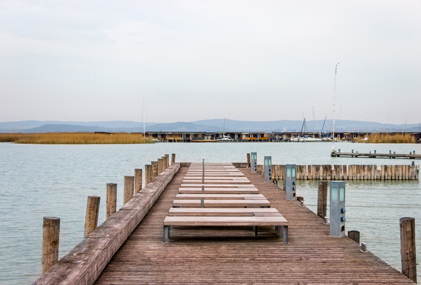 Muelle de madera en el lago con yates en muelles
 - Foto, Imagen
