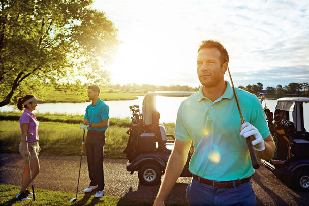 Ας πάμε για γκολφ. Ένας άντρας που παίζει γκολφ με τους φίλους του. - Φωτογραφία, εικόνα