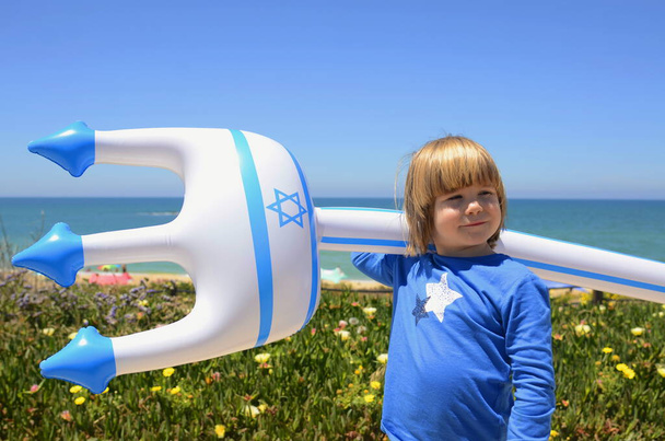 Un petit garçon avec un jouet gonflable avec le drapeau d'Israël et l'étoile de David. Concept : stations balnéaires israéliennes, plages, mer. Jour de l'indépendance d'Israël, patriotisme. - Photo, image