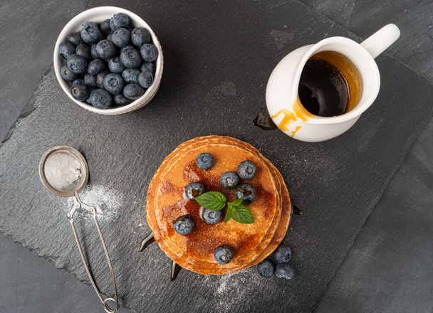 Stapel pannenkoeken met verse bosbessen en karamelsiroop - Foto, afbeelding