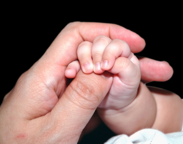 Infant holding adult thumb - Photo, Image