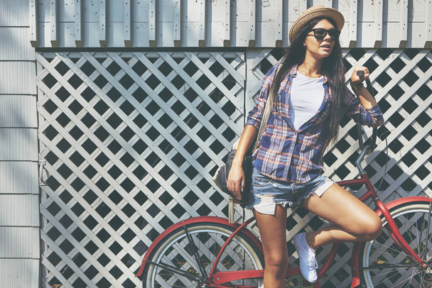 Она передвигается стильно. красивая молодая женщина на велосипеде в парке - Фото, изображение