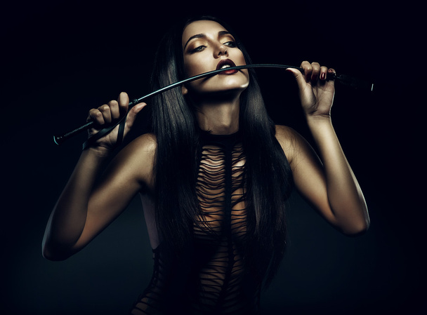 Woman biting whip - Foto, afbeelding