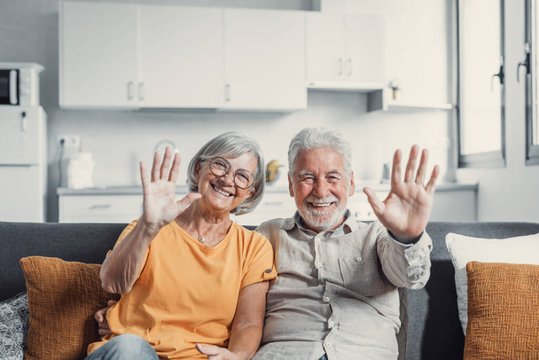 60 Jahre Paar, ältere Eltern kommunizieren mit erwachsenen Kindern mit modernen Technologien macht Videoanruf, winken Hände Geste des Hallo oder Abschiedszeichen, ältere Generation und Internet-Konzept - Foto, Bild