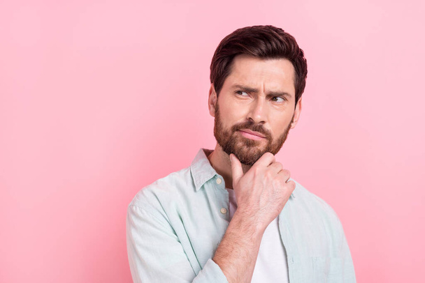 Photo portrait of nice young male look skeptical empty space touch chin dressed stylish blue garment isolated on pink color background. - Foto, imagen