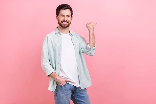 Photo of young confident stylish wear clothes model man wear shirt point finger empty space brand garment isolated on pink color background. - 写真・画像