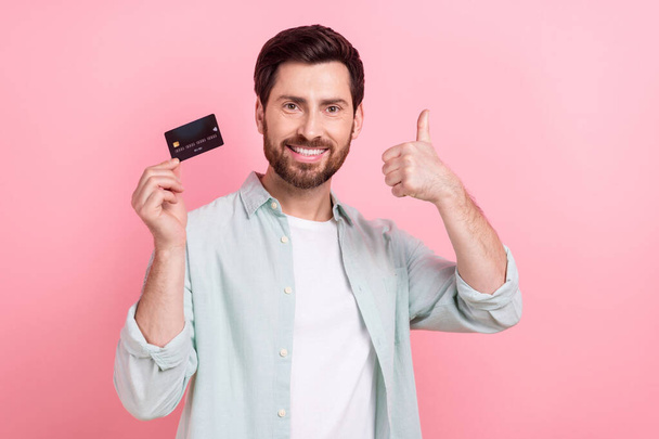 Photo of young banker promoter thumb up recommend new debit credit card wireless payment convenient service isolated on pink color background. - Zdjęcie, obraz