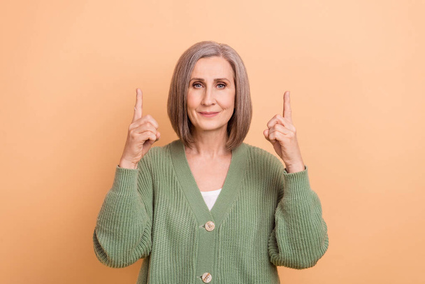 Photo of serious business entrepreneur point fingers empty space wear cardigan recommend information isolated on beige color background. - Фото, зображення