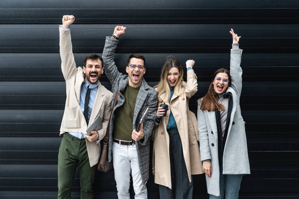 Successful entrepreneurs and businesspeople achieving goals, happy celebrating good deal success and positive business results. Group of working people in front of office building after staff meeting - Photo, Image