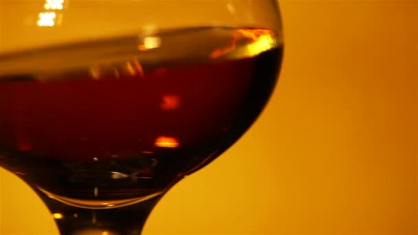 Koniak, whisky w szklance z bliska w czerwone światło - Materiał filmowy, wideo