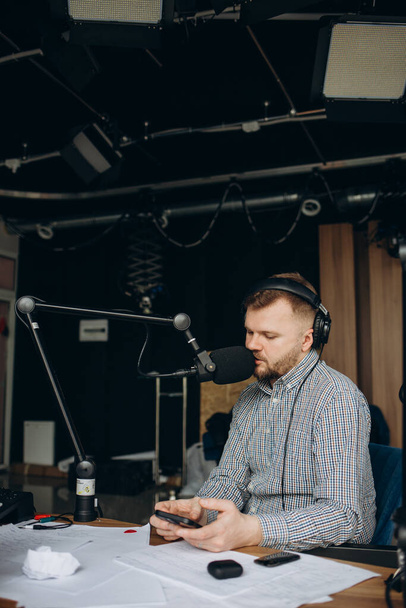 Portrait d'un animateur radio utilisant un mixeur sur table en studio
. - Photo, image