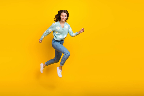 Full length photo of young active model funny girl running jumping fast speed demonstrate her new stylish outfit isolated on yellow color background. - Fotoğraf, Görsel