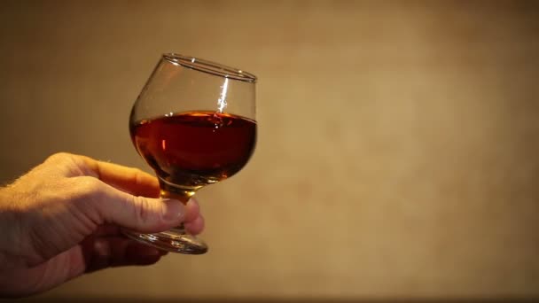 Man's hand with a glass of cognac, brandy - Séquence, vidéo