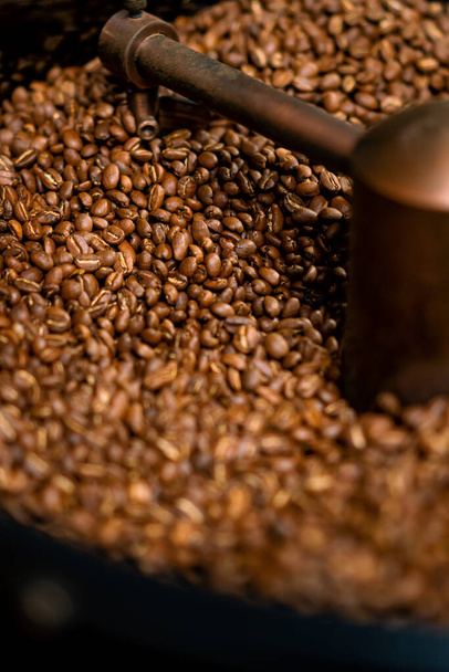Coffee production is the process of roasting fresh coffee beans coffee beans mixed and cooled close-up - Fotoğraf, Görsel