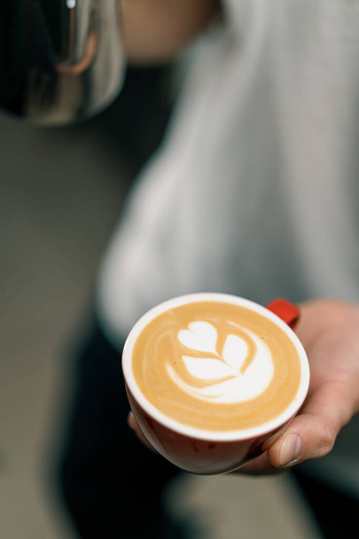 Barista dělat latte art v kavárně Mužské ruce nalévání pára mléka do šálku Cappuccino se vzorem - Fotografie, Obrázek