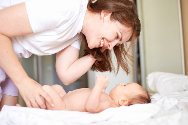 Mother Massaging Her newborn baby boy. Realistic home portrait - Foto, afbeelding