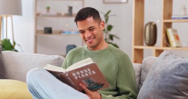 Happy, man and reading a book about plants for learning, knowledge and education on care. Smile, relax and a guy enjoying studying about caring for a plant, interesting facts and tips at home. - Footage, Video