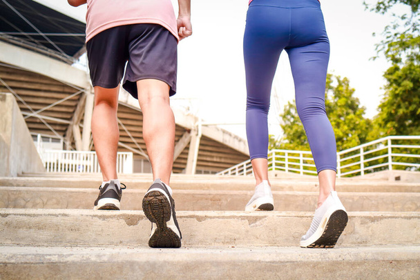 Zwei junge Paare in Sportkleidung laufen früh am Tag die Treppe hinauf zum Outdoor-Training. Sportlerinnen und Sportler. Sportkonzept. Bewegung für einen gesunden Lebensstil. - Foto, Bild