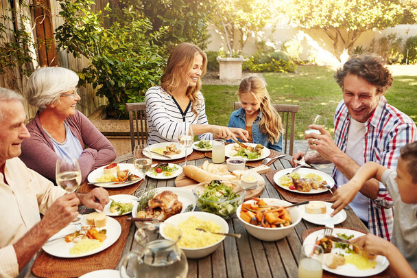幸せは家族と日曜日のランチです。屋外で一緒に昼食を食べる家族 - 写真・画像