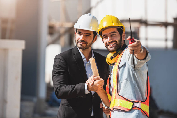 Teamwork-Männer auf der Baustelle, zwei Bauingenieure mit Schutzhelm und digitalem Tablet und Blaupause bei der Arbeit im Werk. - Foto, Bild