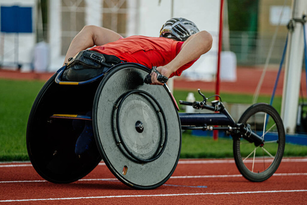close-up para atleta en silla de ruedas montando en el estadio de pista roja, campeonatos de atletismo para verano - Foto, Imagen