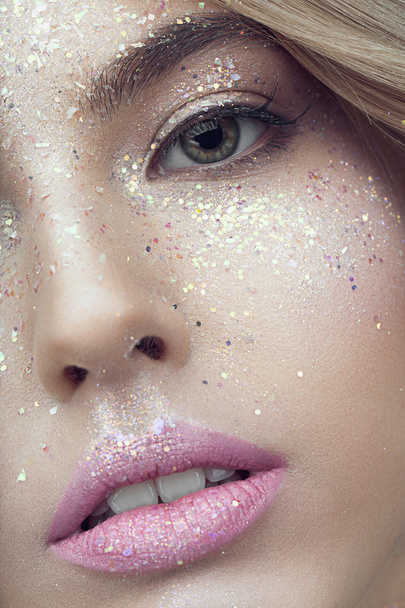 vrouw gezicht met glitters op gezicht - Foto, afbeelding