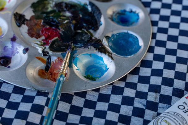 A closeup shot of a metal palette with mixed paints at a studio - Photo, Image