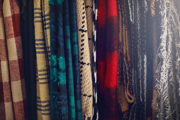 El clima puede ser frío, tu estilo no debería serlo. Primer plano de bufandas colgando en una tienda - Foto, Imagen