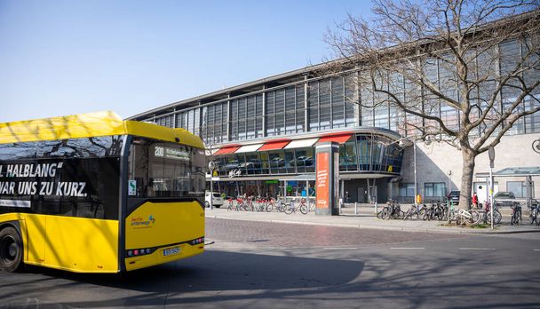 A yellow bus in front of the Berlin Zoologischer Garten bus station in Berlin, Germany - Фото, изображение