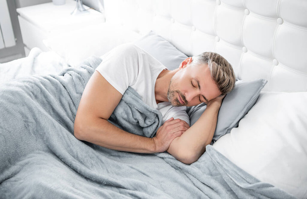 mature man sleeping in bedroom. early morning. - Фото, зображення