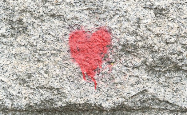 Un pequeño símbolo genérico de corazón rojo pintado en una pared, vista frontal del icono del corazón, primer plano, área urbana, arquitectura, edificio lado pulverización pintado corazón. Amor, afecto simple símbolo abstracto concepto, nadie - Foto, Imagen