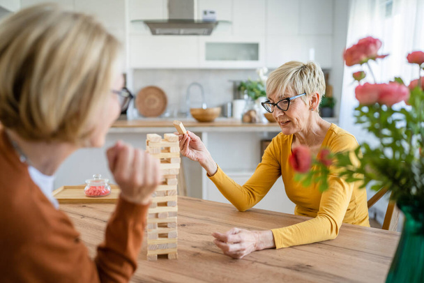 dwie starsze kobiety przyjaciółki lub siostry rodziny grać w gry planszowe rekreacji w domu zabawy emeryt babcia spędzić czas wraz z ich dojrzałej córki - Zdjęcie, obraz