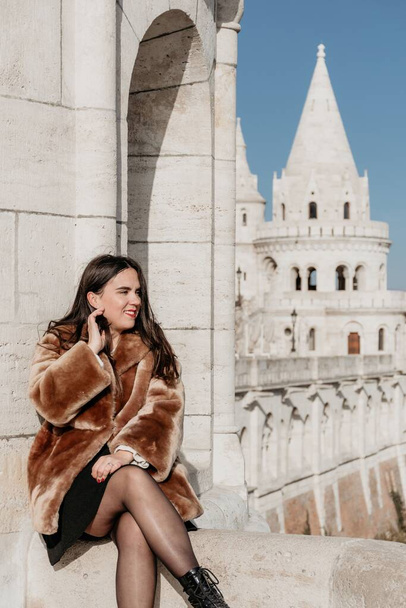 A vertical shot of a happy young woman in front of cityscape in Budapest, Hungary - Photo, image