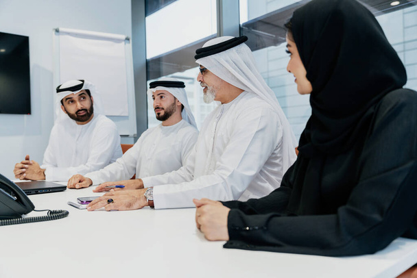 Group of middle-eastern corporate business people wearing traditional emirati clothes meeting in the office in Dubai - Business team working and brainstorming in the UAE - Fotoğraf, Görsel