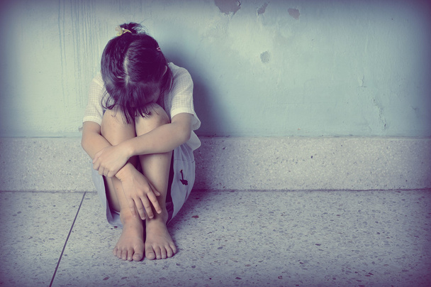 sad and depressed little girl sitting near the wall - Foto, Bild