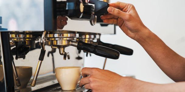 Close up of male barista preparing coffee at espresso machine in cafe. Coffee preparation service concept - Zdjęcie, obraz