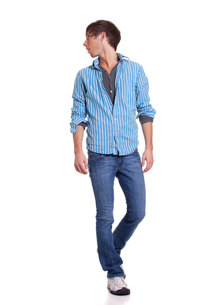 Young man in blue jeans and shirt. Studio shot over white. - Valokuva, kuva