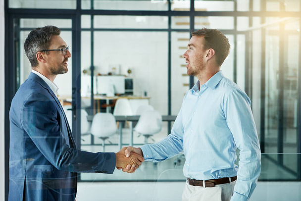 Temblando por un trabajo excepcional. dos hombres de negocios estrechando la mano en una oficina - Foto, Imagen