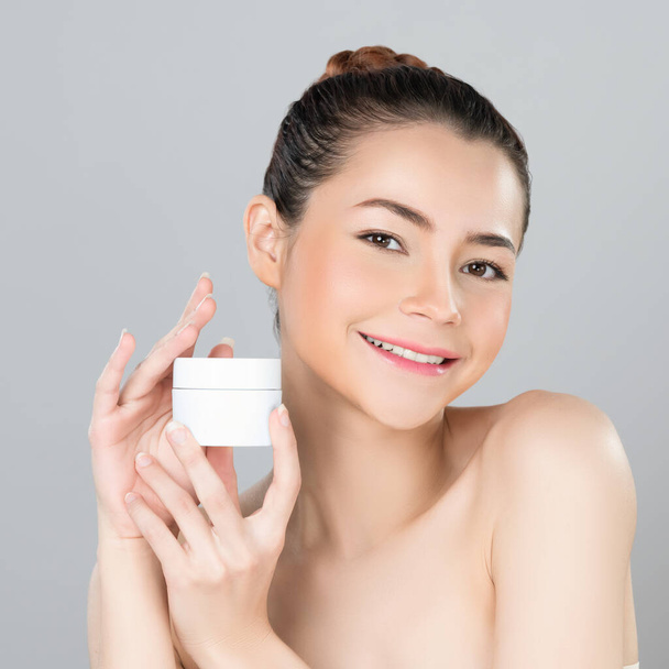 Glamorous beautiful perfect cosmetic skin with soft makeup woman portrait hold mockup jar cream or moisturizer for skincare treatment and anti-aging product advertisement in isolated background. - Photo, Image