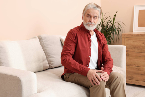 Senior man suffering from pain in his knee at home. Arthritis symptoms - Φωτογραφία, εικόνα