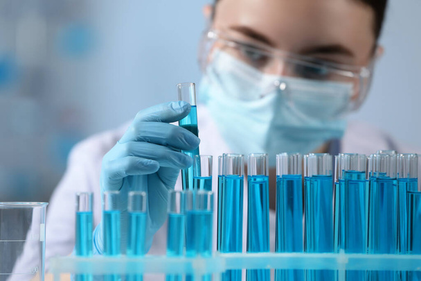 Ученый держит пробирку с образцом в лаборатории, избирательный фокус - Фото, изображение