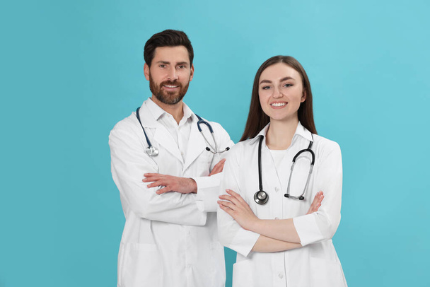 Nurses in medical uniforms with stethoscopes on light blue background - Foto, afbeelding