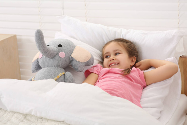 Happy little girl awaking in cosy bed - Фото, изображение